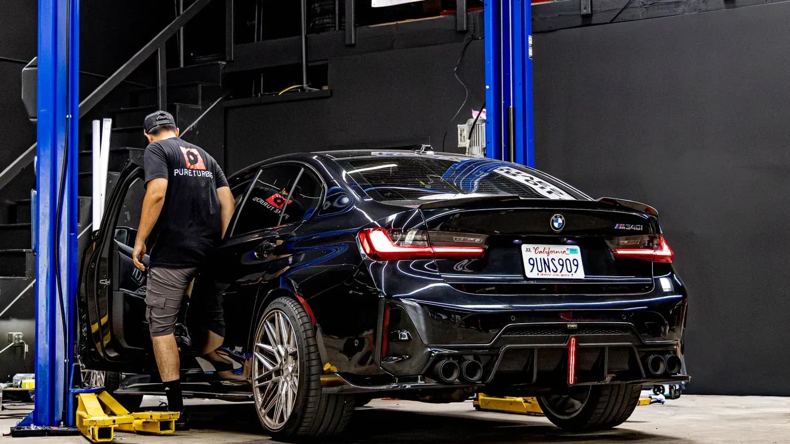 Technician working with a BMW performance sedan in the Speedhaus service bay