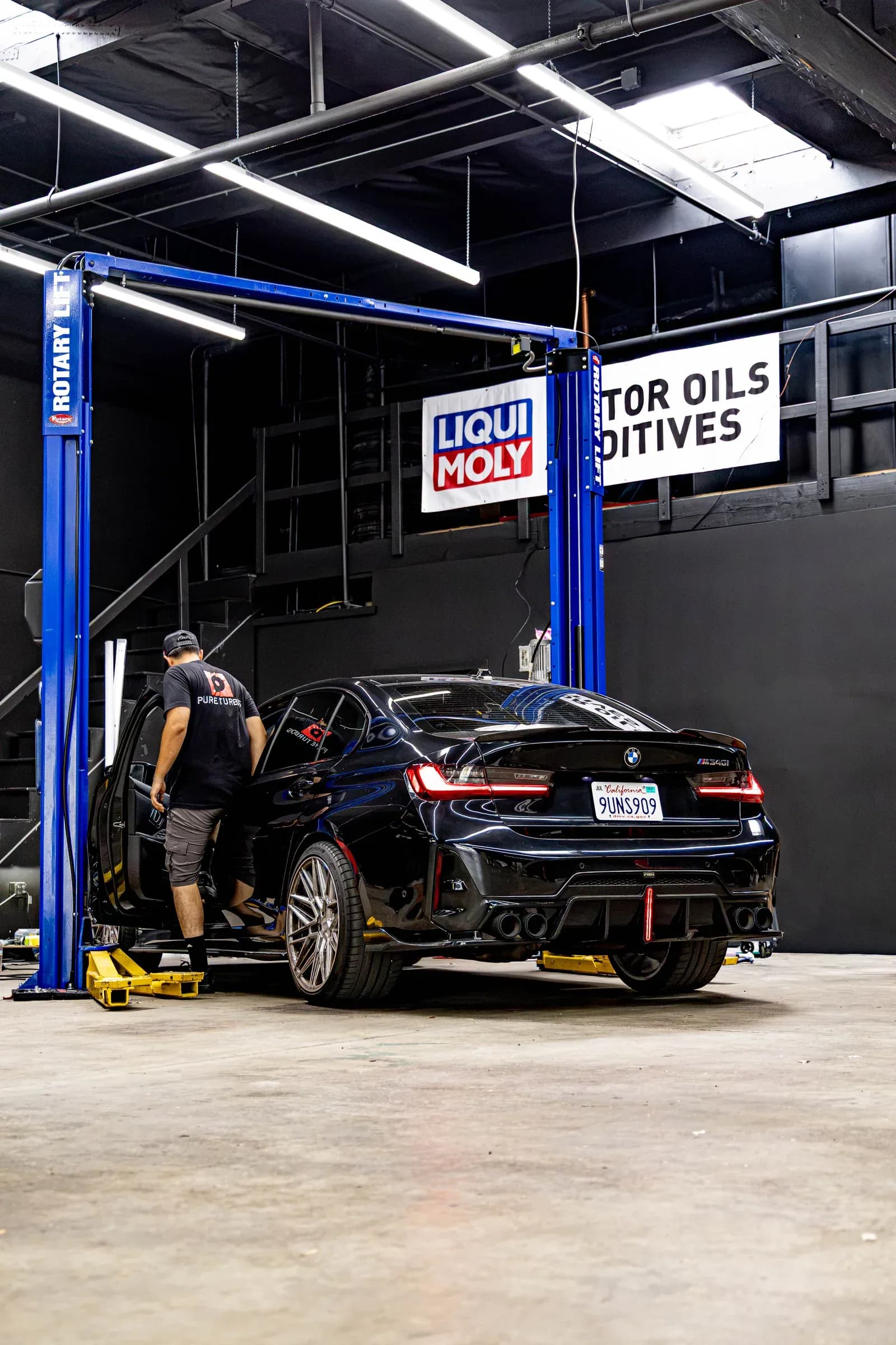 Technician working with a BMW performance sedan in the Speedhaus service bay